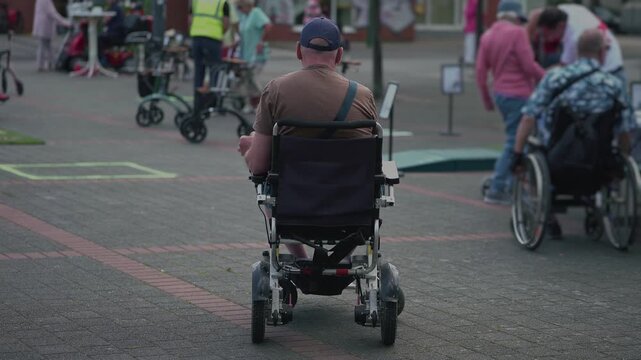 Group of wheelchair users gathers outdoors and shares a relaxed moment together, illustrating peer support, friendship, social connection, disability inclusion, community belonging.