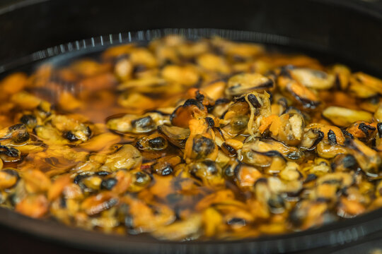 Close up of cooked mussel meat in a pan. Seafood ingredient prepared for culinary cooking, savory meal preparation, restaurant cuisine