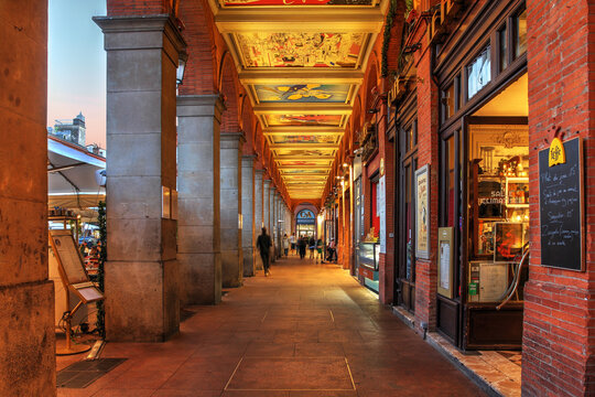 Arcades du Capitole with murals of Raymond Moretti at night in Toulouse, France