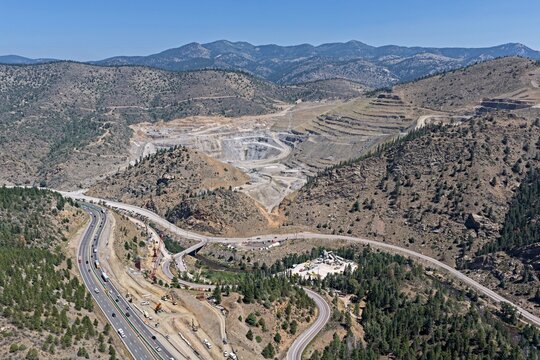 Aerial view of the winding highway and construction activity near the mountainous landscape of Floyd Hill, Colorado, United States.