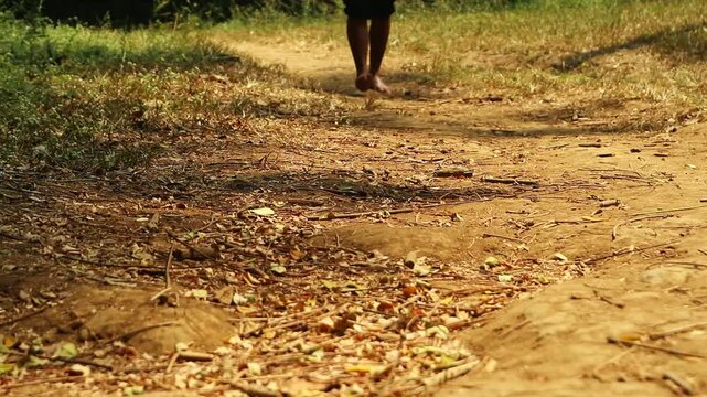 A person walking barefoot on a dusty rural path in the countryside, grounding with the Earth's natural energy to reduce stress, restore inner balance, and revitalize the mind