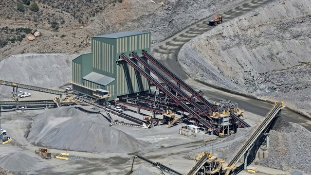 Aerial view of the Floyd Hill quarry facility with processing buildings, conveyor belts, piles of crushed rock, and heavy mining equipment in Floyd Hill, Colorado, United States.