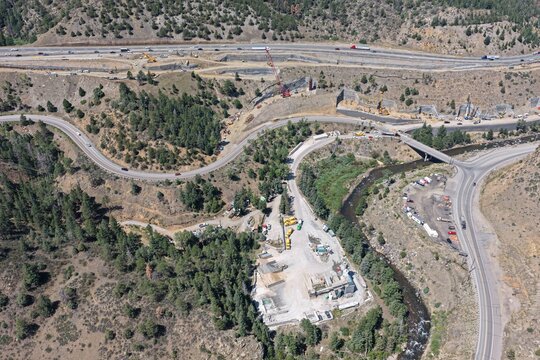 Aerial view of the highway construction project at Floyd Hill featuring winding roads, heavy machinery, and mountainous terrain in Floyd Hill, Colorado, United States.