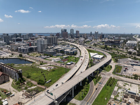Aerial view of the Tampa skyline featuring a complex highway interchange with multi-level roads, modern skyscrapers, and surrounding urban development in Tampa, Florida, United States.