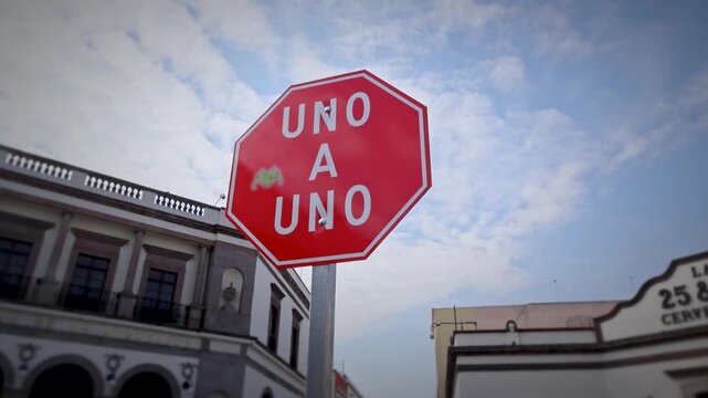 Uno A Uno Red Octagonal Traffic Sign At Intersection With Historic Building