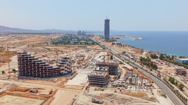 Aerial view of the Ellinikon construction site with cranes and unfinished modern buildings along the coastline in Athens, Greece.