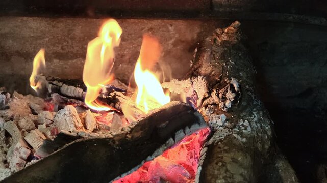 Close-up video of firewood and glowing charcoal burning for a traditional Argentine asado.