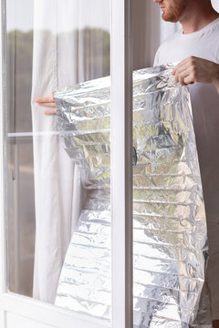 Man holding unrolled sun protection foil film for windows.