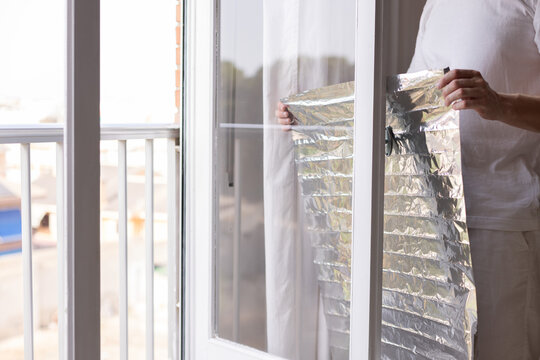 Man holding unrolled sun protection foil film for windows.