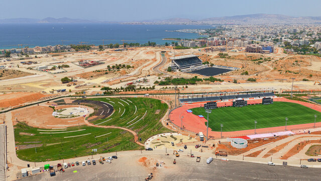 Aerial view of the Ellinikon construction site featuring a stadium, green spaces, and ongoing urban development in Athens, Greece.