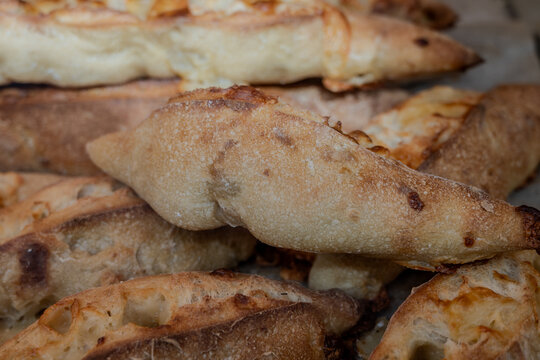 Handcrafted sourdough baguettes made in artisanal bakery in Marais, Paris with long fermentation with cheese, olives and aromatic herbs, and crisp crust