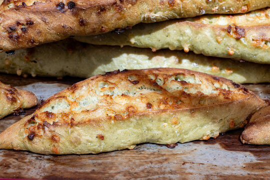 Handcrafted sourdough baguettes made in artisanal bakery in Marais, Paris with long fermentation with cheese, olives and aromatic herbs, and crisp crust