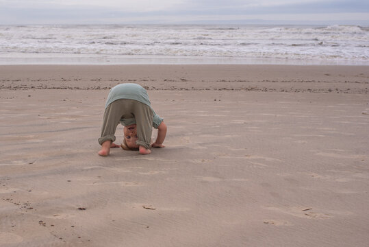 Playful Baby Doing a Headstand on the beach