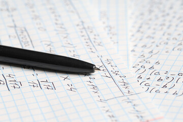 Fototapeta premium Copybook with handwritten maths formulas and pen as background, closeup