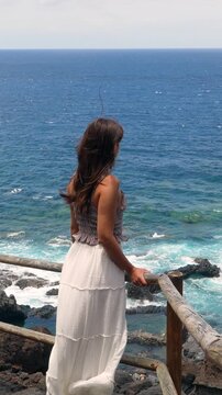 Woman watching the ocean waves from a viewpoint on el hierro