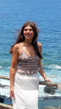 Cheerful woman celebrating freedom by the sea