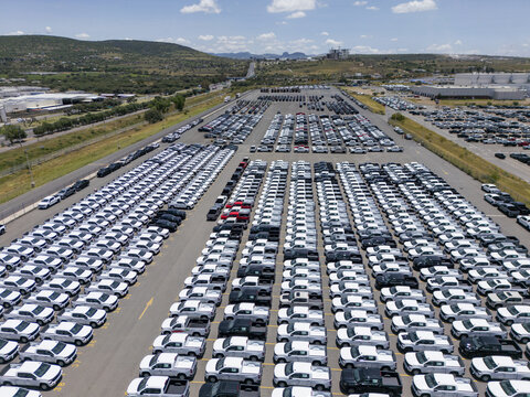 Aerial view of rows of new pickup trucks parked in a large outdoor lot at a car factory in San Luis Potosi, San Luis Potosi, Mexico.