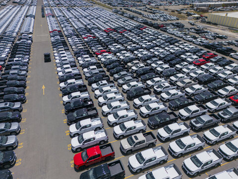 Aerial view of a car factory parking lot filled with numerous pickup trucks in rows, showcasing industrial logistics and automotive distribution in San Luis Potosi, San Luis Potosi, Mexico.