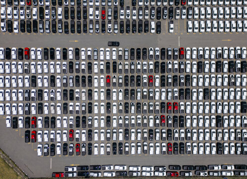 Aerial view of a car factory parking lot filled with rows of new pickup trucks in various colors parked on asphalt in San Luis Potosi, San Luis Potosi, Mexico.