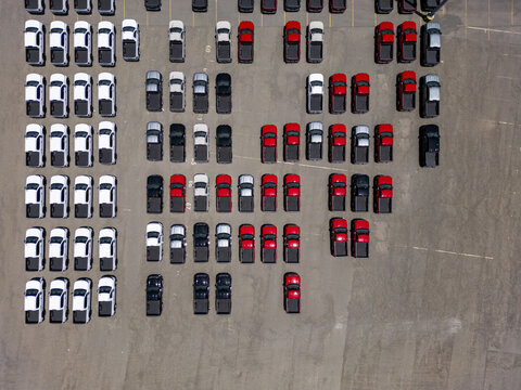 Aerial view of Car Factory with rows of new white, black, and red pickup trucks parked in an organized lot in San Luis Potosi, San Luis Potosi, Mexico.