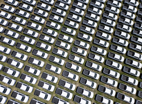 Aerial view of a car factory lot filled with rows of new white pickup trucks parked in an organized grid pattern in San Luis Potosi, San Luis Potosi, Mexico.