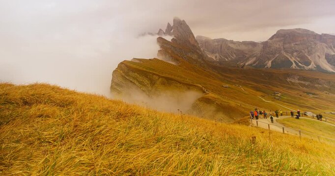 4K Scenic view of Seceda mountain peak covered in morning fog during autumn in Dolomites Italy