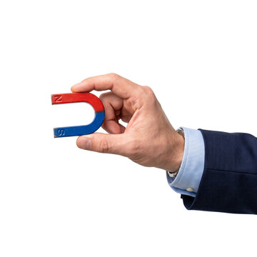 Businessman holding a horseshoe magnet isolated on white background