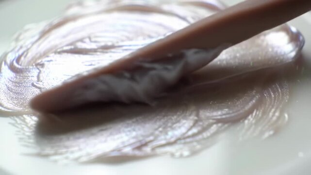 Applying iridescent cosmetic product on white surface