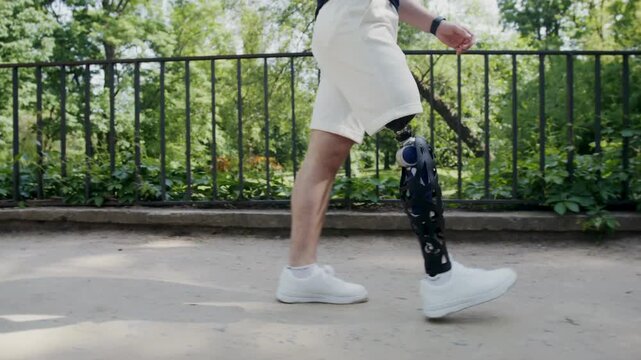 Low angle shot of a person walking with an advanced bionic prosthetic leg in a sunny park.