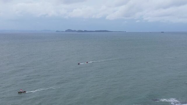 Scenic drone flight over Anyer Beach featuring gentle waves and a tropical shoreline in Banten, Indonesia.