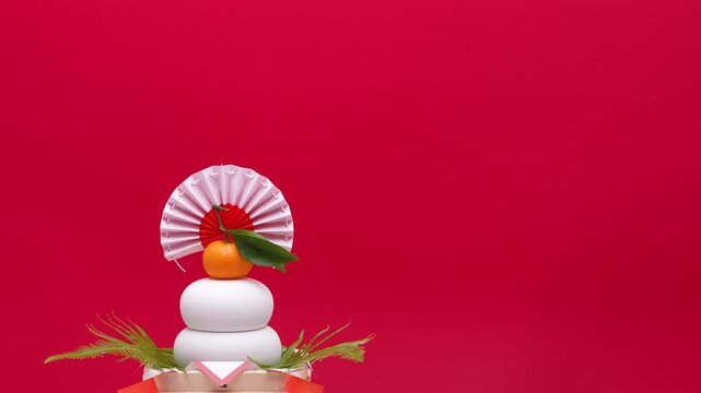鏡餅を左側に配置し、赤白背景でティルトダウン撮影した動画　低い三宝