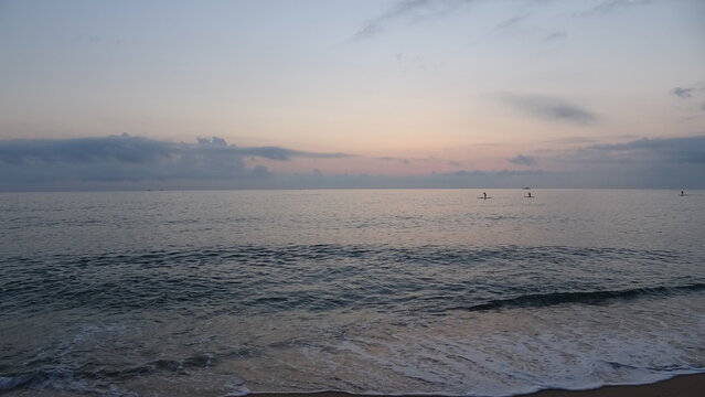 Stand Up Paddle Boarders at Dawn in Gangneung.
Tranquil morning seascape at dawn in Gangneung, South Korea, featuring paddle boarders silhouetted on calm ocean under a subtle pastel sky.
