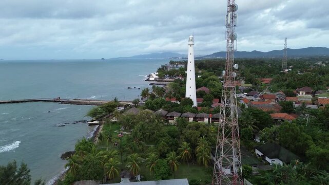 Cinematic drone footage capturing Mercusuar Titik Nol (Zero Point Lighthouse) in Anyer, Banten, Indonesia. The aerial view showcases the iconic lighthouse, surrounding coastline, the Java Sea (Sunda S