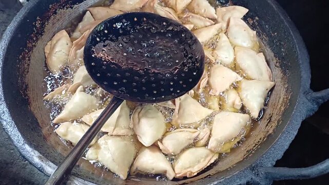 Deep Frying Samosa Singara Snacks In Boiling Hot Oil Overhead Close Up Shot