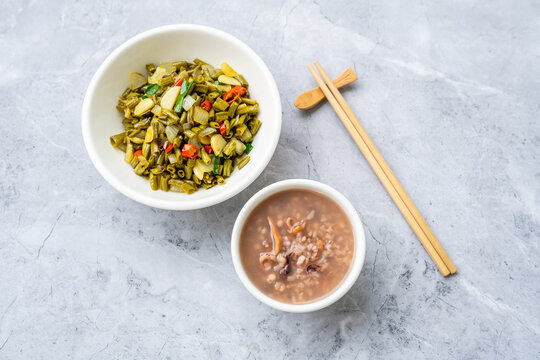 A bowl of cuttlefish and Job's-tears porridge served with stir-fried sour long beans.