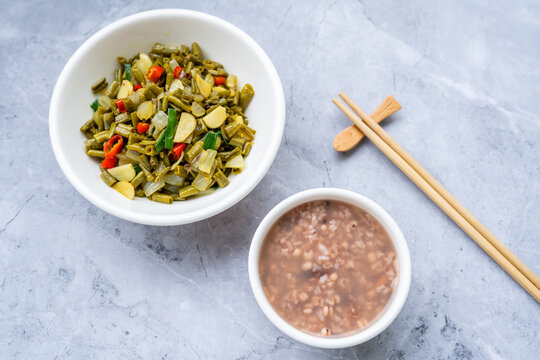 A bowl of cuttlefish and Job's-tears porridge served with stir-fried sour long beans.