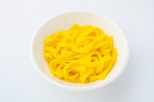 A bowl of golden-yellow corn starch noodles