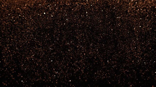 Copper-bronze metallic dust cascades downward in soft veil through dark viscous liquid, catching dramatic light against black with opulent texture, refined motion, and generous copy space.