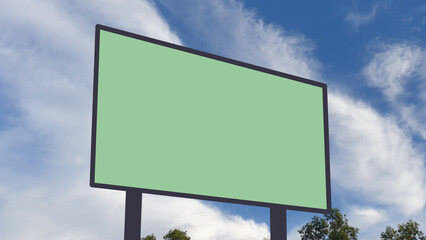 Fototapeta premium Blank billboard mockup with green screen against a blue sky with clouds, ideal for outdoor advertising, marketing, and promotional banner design.
