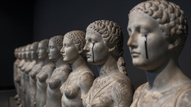 Row of Classical Statues with Tearful Expressions in a Gallery