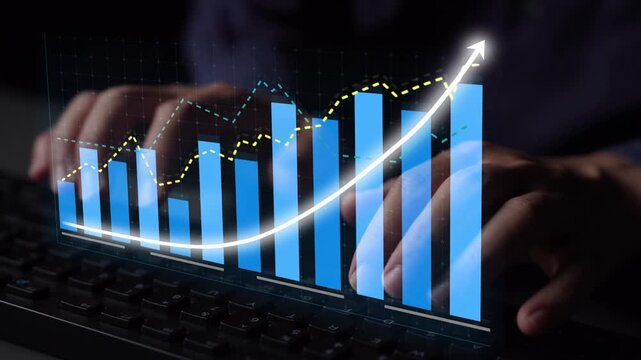 A professional working on a keyboard while analyzing financial graphs in a modern office environment, showcasing data visualization and business growth concepts. Copula