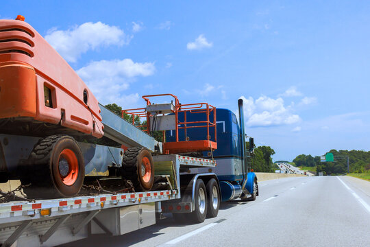 Truck transporting construction equipment on highway