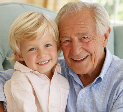 Grandfather and grandson sitting close, embracing and smiling, representing family bonds, youth, and wisdom through generations