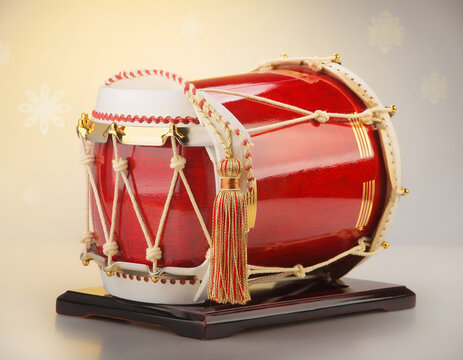 A traditional Japanese taiko drum with a vibrant red body sits on a display stand.