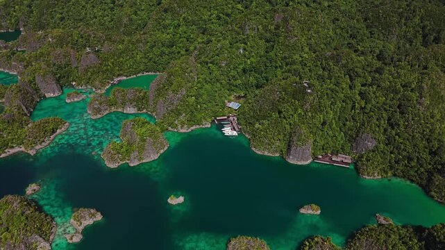 Aerial drone view of the iconic Piaynemo karst islands in Raja Ampat, Indonesia. Turquoise waters surround dramatic limestone formations and lush green islands, creating a spectacular tropical seascap