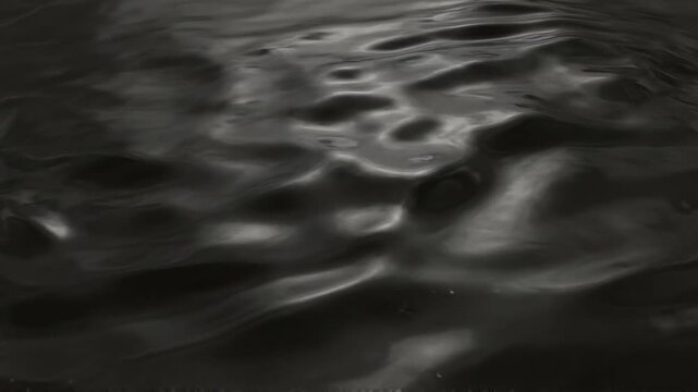 Dark Gunmetal Liquid Foil Undulating in Smooth Waves for Moody Abstract Backgrounds