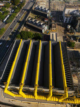 Aerial view of the thermoelectric power plant featuring large yellow pipes, cooling towers, and industrial infrastructure in Merida, Yucatan, Mexico.