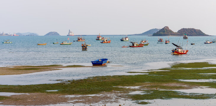 Traditional fishing boats floating in calm coastal waters at Dongtan Gulf in Sattahip Chon Buri Thailand. View of Thai fishing boats anchored near Dongtan Beach, Sattahip, Chon Buri, Thailand.