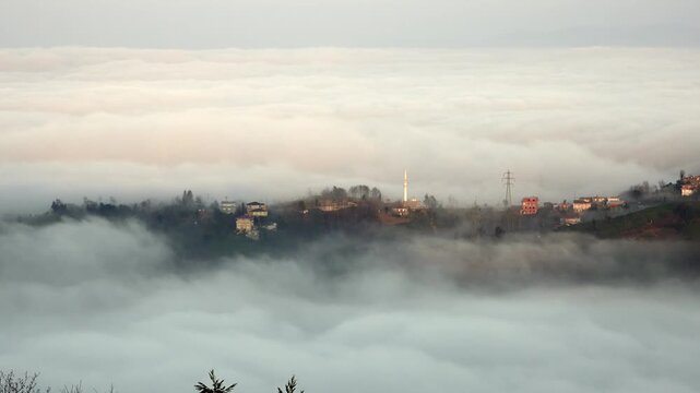 Rize Turkey mountain village mosque rises above sea of clouds and misty green hills.