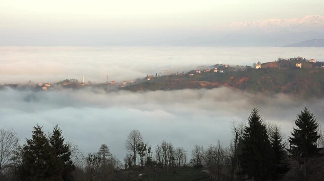 Rize Turkey mountain village mosque rises above sea of clouds and misty green hills.